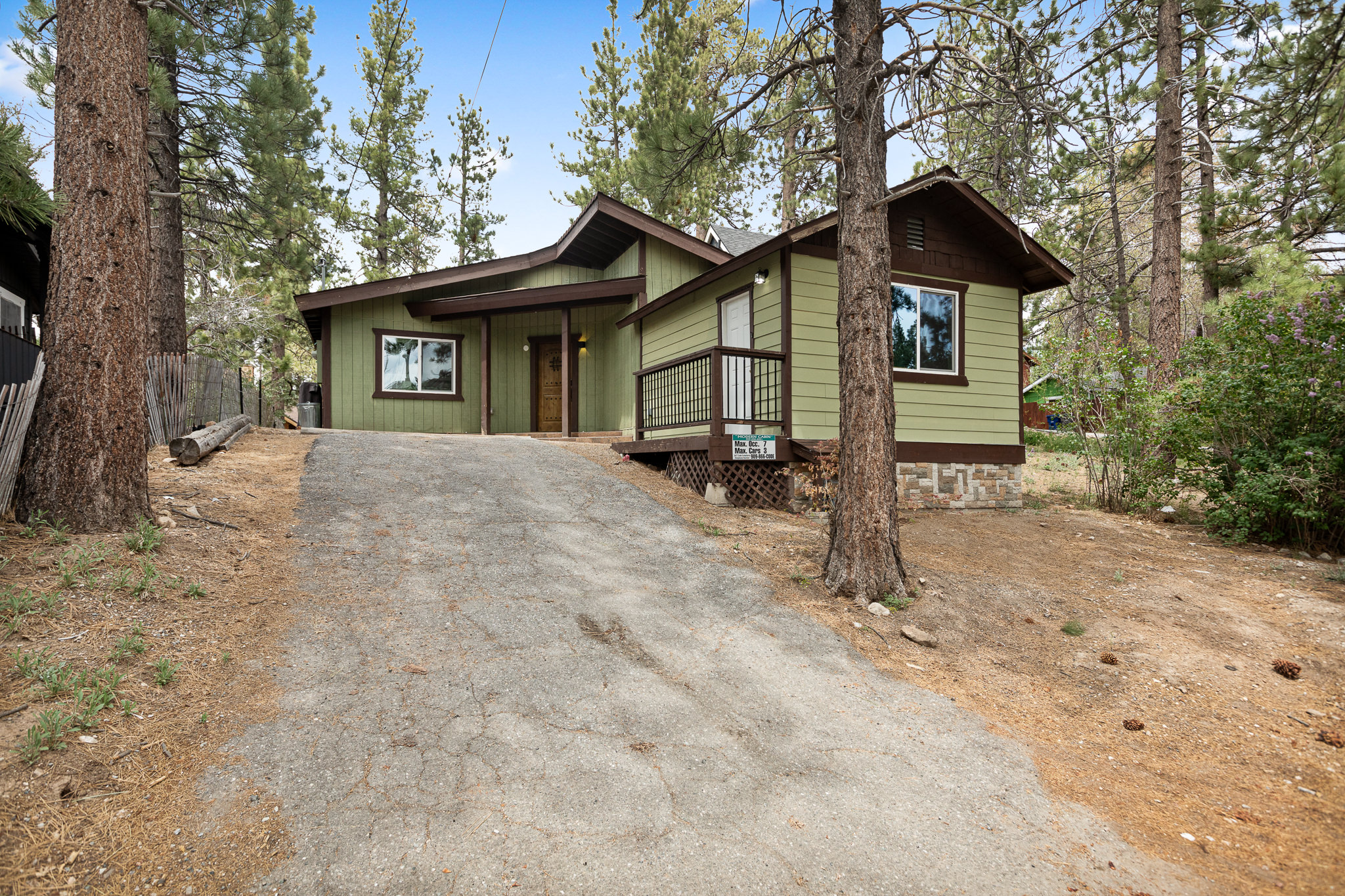 The Big Bear Cubhouse cabin glowing at dusk among pine trees